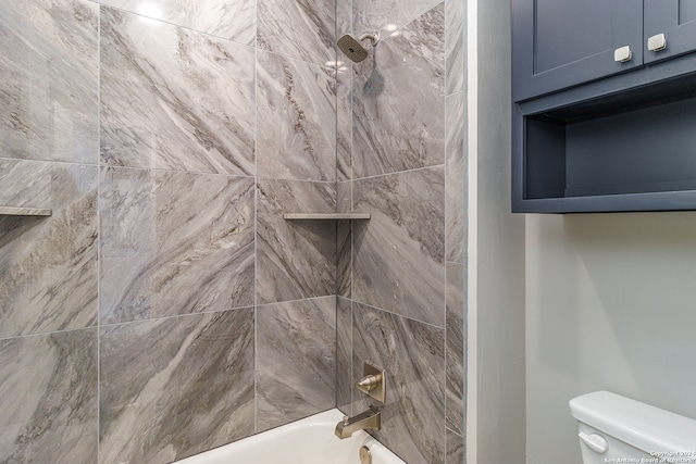 bathroom with toilet and tiled shower / bath