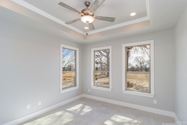 unfurnished room featuring a tray ceiling, ceiling fan, and crown molding