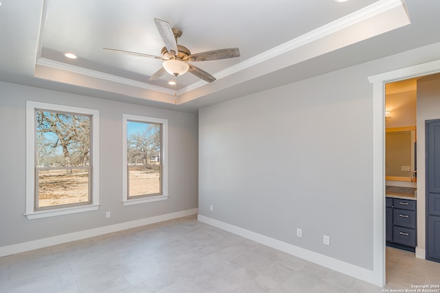 spare room featuring a tray ceiling, ceiling fan, and ornamental molding