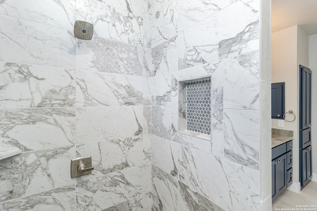 bathroom with vanity and a tile shower