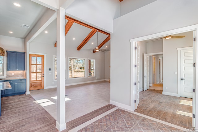 entryway featuring beamed ceiling, a high ceiling, and ceiling fan