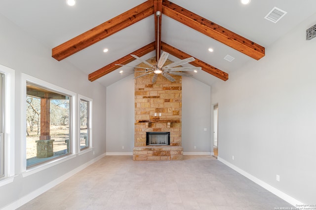 unfurnished living room with ceiling fan, beam ceiling, a fireplace, and high vaulted ceiling