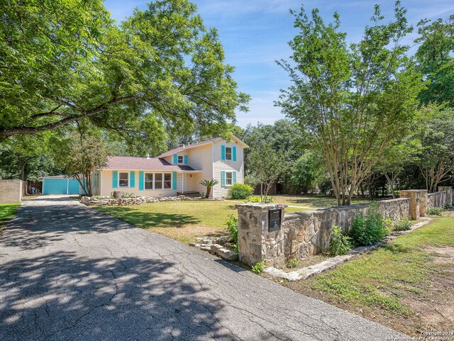 tri-level home featuring a garage and a front lawn