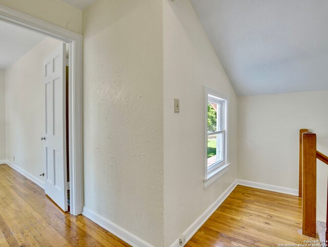 hall featuring vaulted ceiling and light hardwood / wood-style flooring