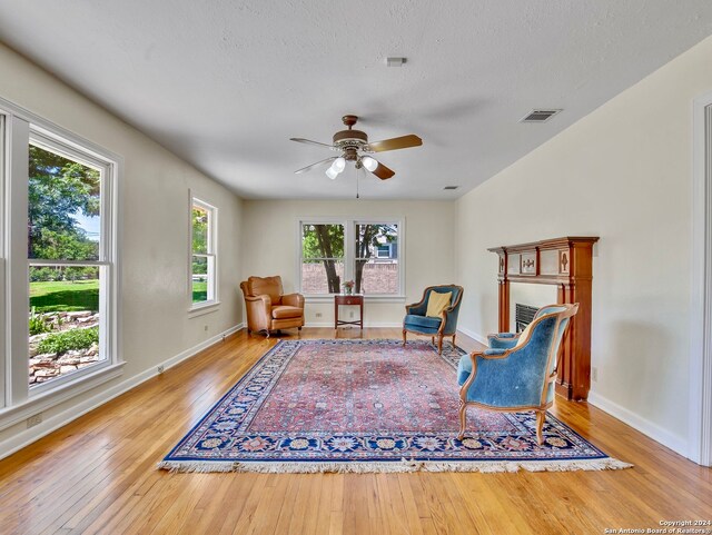 living area with ceiling fan and light wood-type flooring