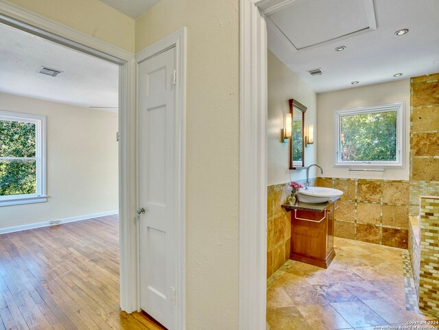 bathroom featuring tile flooring, tile walls, and vanity