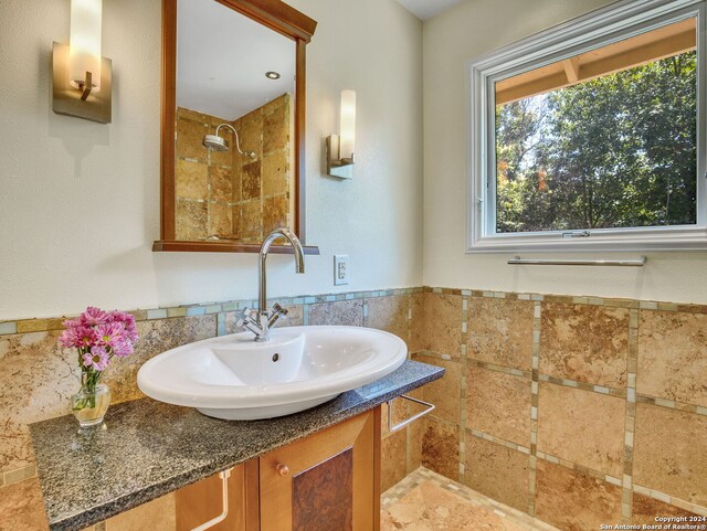 bathroom featuring tiled shower and vanity