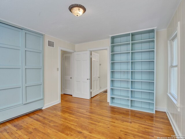 unfurnished bedroom with light hardwood / wood-style floors and multiple windows