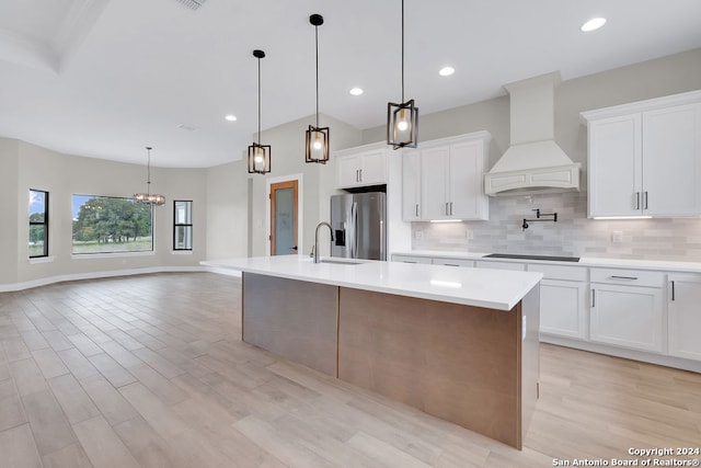 kitchen with white cabinetry, light hardwood / wood-style flooring, custom exhaust hood, decorative backsplash, and stainless steel refrigerator with ice dispenser