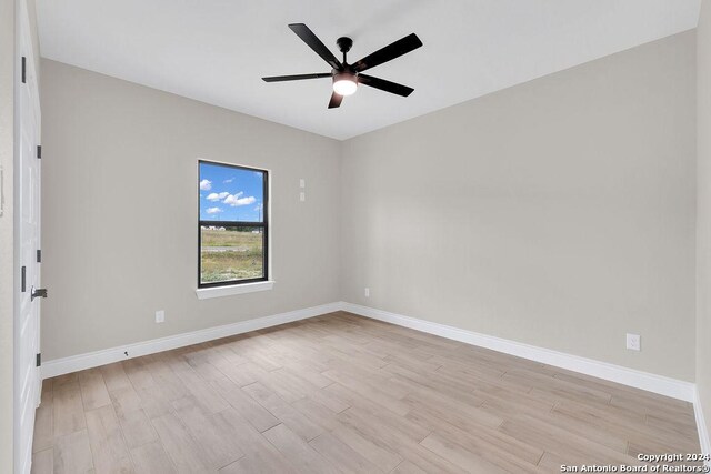 spare room featuring light hardwood / wood-style floors and ceiling fan