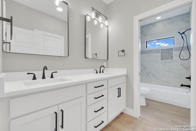 full bathroom with tiled shower / bath combo, toilet, and double sink vanity