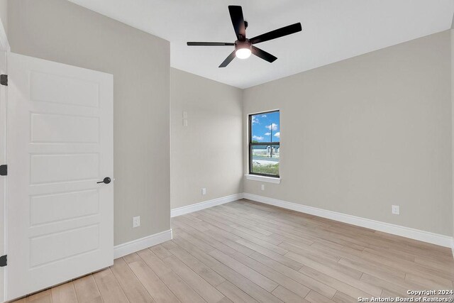 empty room with light wood-type flooring and ceiling fan