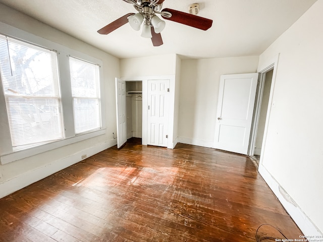 unfurnished bedroom featuring ceiling fan and dark wood-type flooring