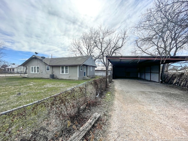 view of front of house featuring central air condition unit, a carport, and a front lawn