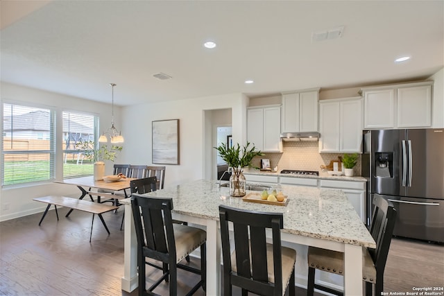 kitchen featuring backsplash, pendant lighting, stainless steel appliances, and white cabinetry