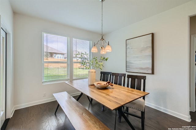 dining area with dark hardwood / wood-style floors and an inviting chandelier