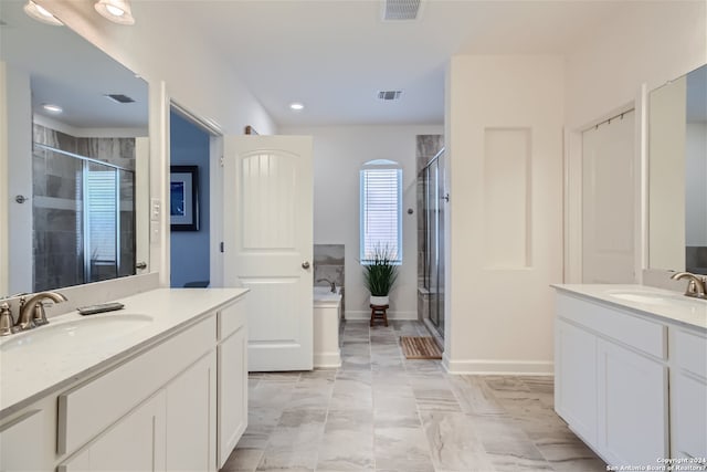 bathroom with walk in shower, dual sinks, large vanity, and tile flooring