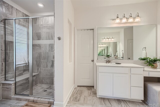 bathroom with tile floors, a shower with shower door, and oversized vanity