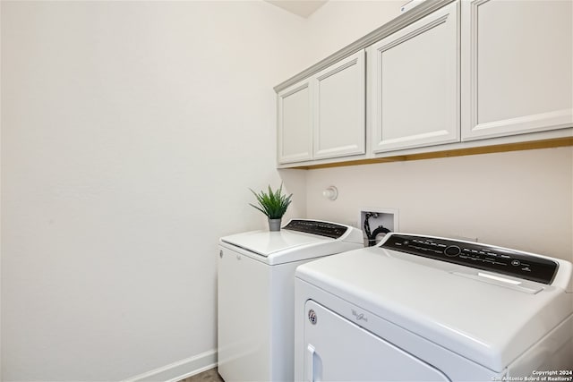 laundry room featuring washer hookup, washer and clothes dryer, and cabinets