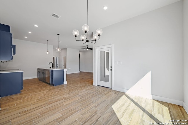 interior space featuring a center island with sink, a notable chandelier, light hardwood / wood-style flooring, and pendant lighting