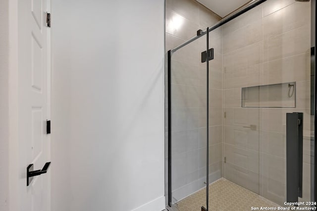 bathroom featuring a shower with shower door