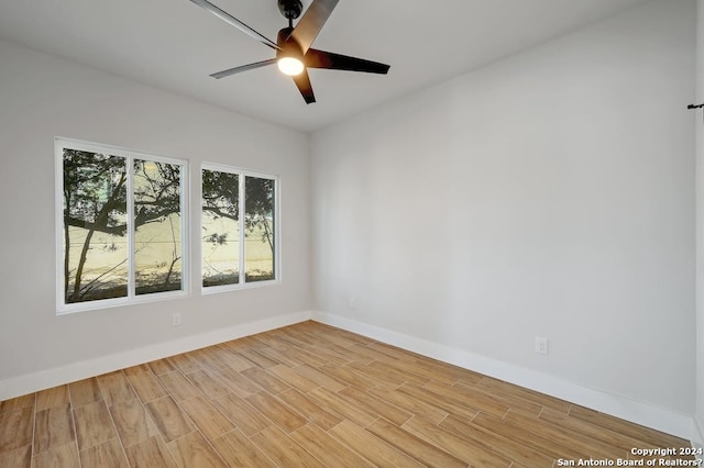 spare room featuring a healthy amount of sunlight, ceiling fan, and light wood-type flooring