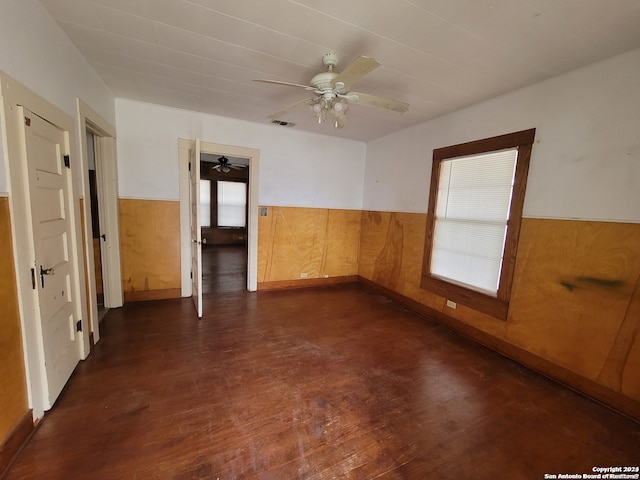 empty room with dark hardwood / wood-style flooring and ceiling fan