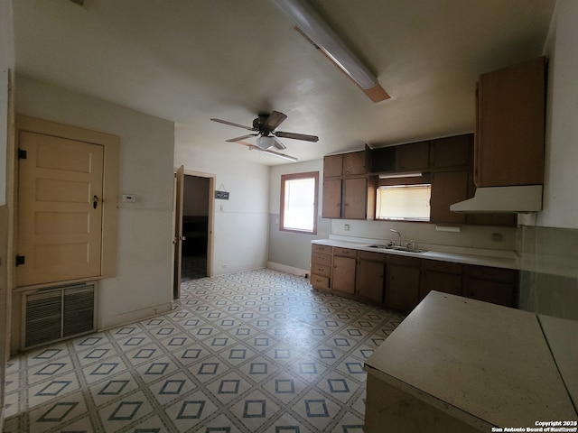 kitchen featuring light tile flooring, ceiling fan, and sink