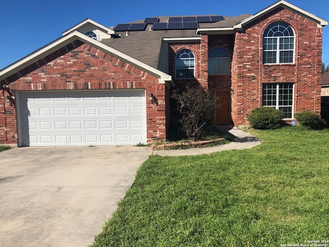 view of front property with a front lawn, a garage, and solar panels