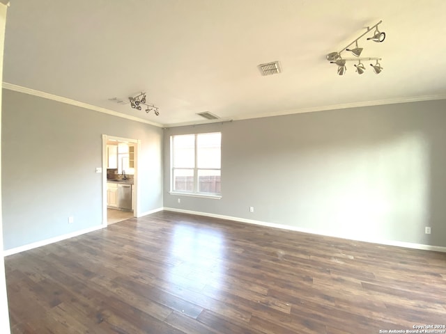 unfurnished room featuring track lighting, crown molding, and dark hardwood / wood-style flooring