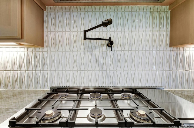 interior details featuring stainless steel gas cooktop and backsplash