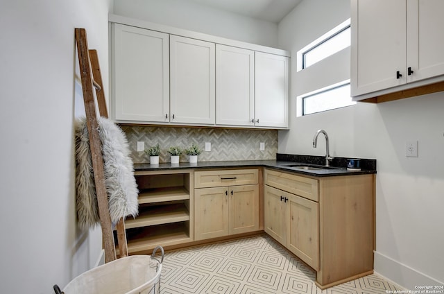 kitchen with backsplash, light brown cabinetry, sink, and light tile floors