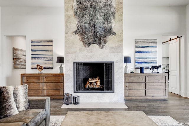 living room featuring a barn door and dark wood-type flooring