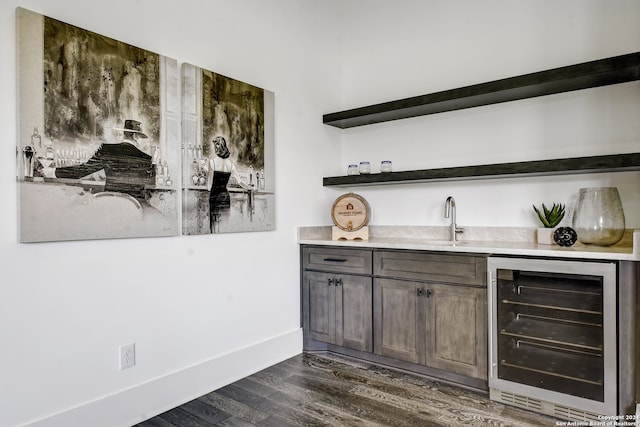 bar featuring dark brown cabinetry, wine cooler, sink, and dark hardwood / wood-style flooring