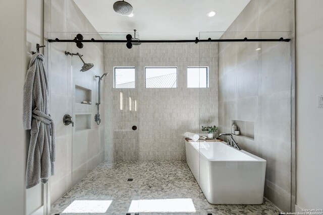 bathroom with walk in shower, tile walls, and tile floors