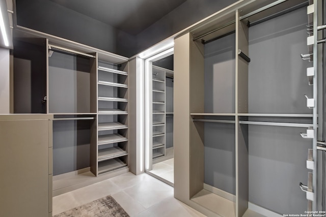 walk in closet with light tile floors