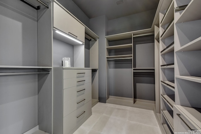 spacious closet with light tile flooring