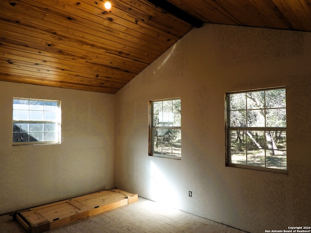 spare room with vaulted ceiling with beams, wood ceiling, and a healthy amount of sunlight