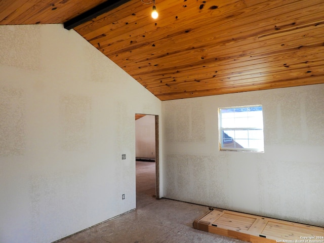 empty room with concrete floors, wooden ceiling, and vaulted ceiling with beams