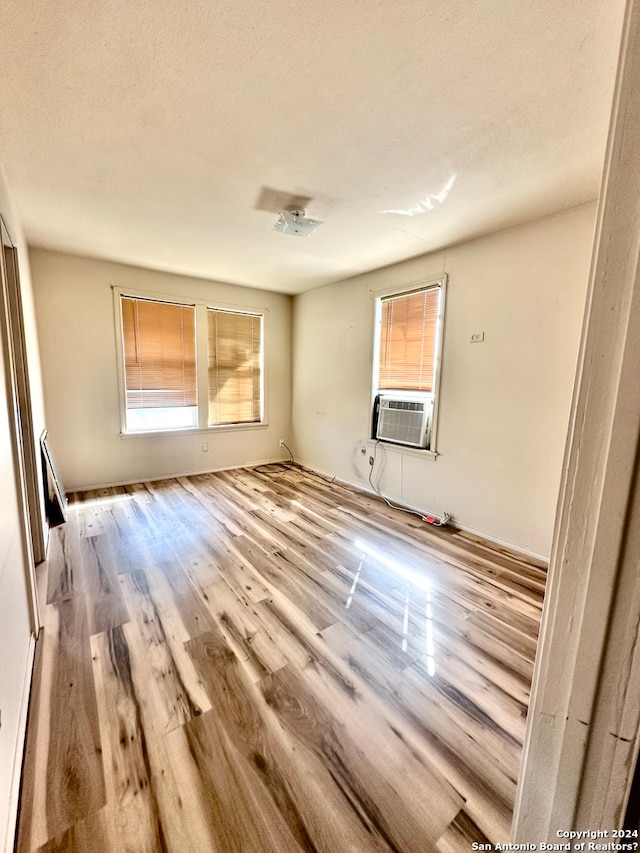 empty room with a textured ceiling and light wood-type flooring