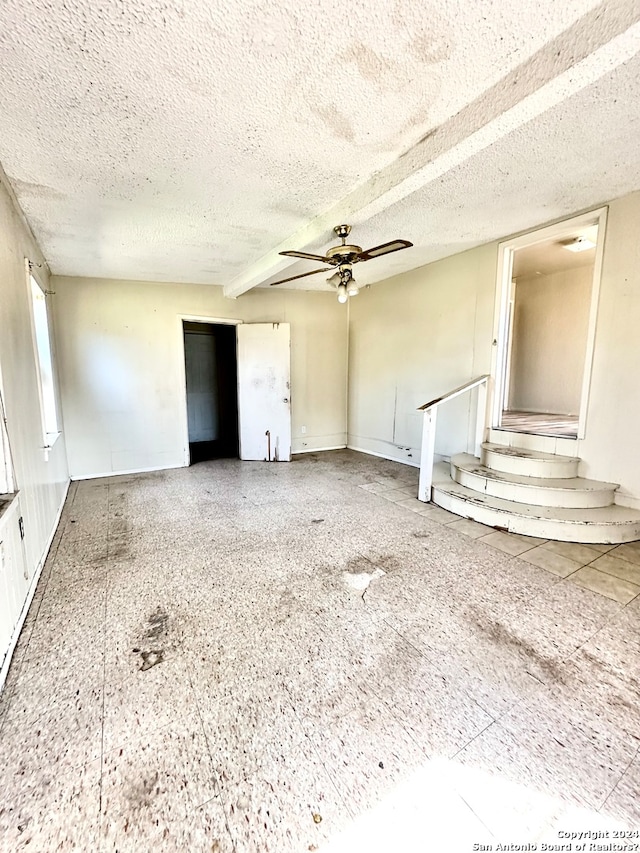 spare room with ceiling fan and a textured ceiling