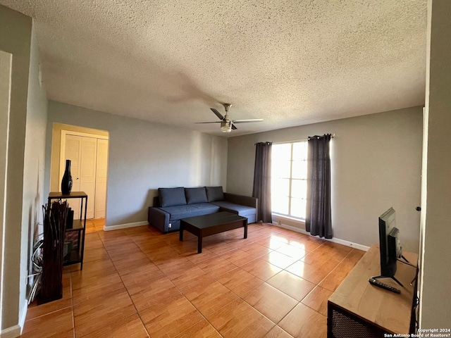 tiled living room featuring ceiling fan and a textured ceiling