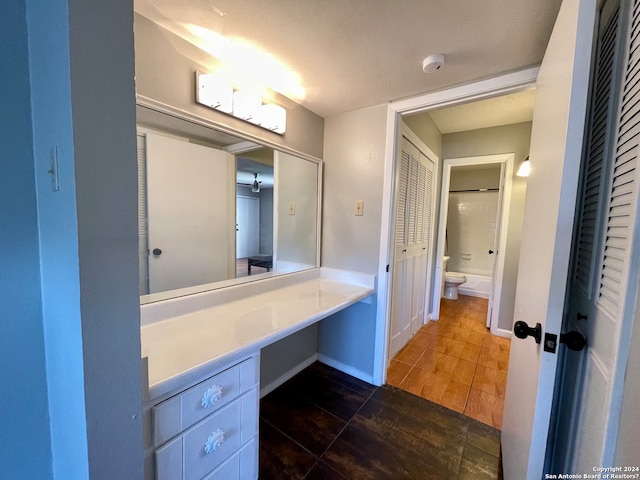 bathroom with vanity, tile floors, and toilet