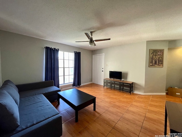 tiled living room with a textured ceiling and ceiling fan