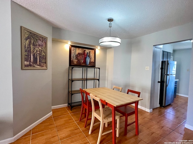 tiled dining room with a textured ceiling