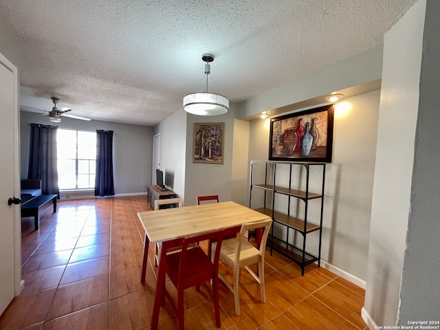 dining space featuring a textured ceiling, tile floors, and ceiling fan