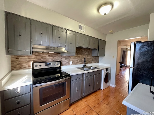 kitchen with electric stove, refrigerator, tasteful backsplash, washer / clothes dryer, and sink