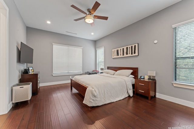 bedroom with ceiling fan, dark hardwood / wood-style floors, and multiple windows