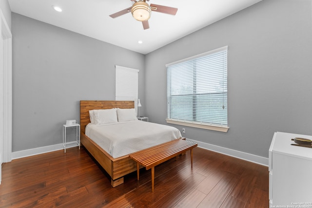 bedroom with dark hardwood / wood-style flooring and ceiling fan