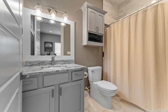 bathroom featuring tile floors, oversized vanity, and toilet